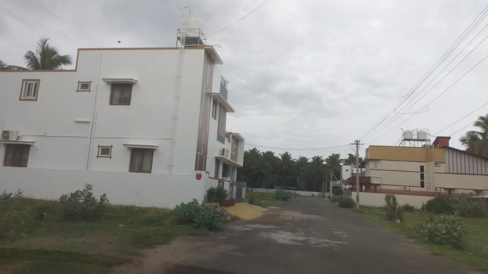 Completed homes along a blacktop road at Venkadeshwara Avenue, Panikkampatti, Pollachi